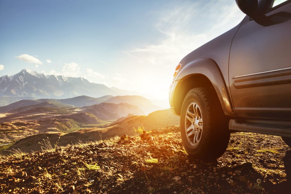 4wd car on wheel against sunset.