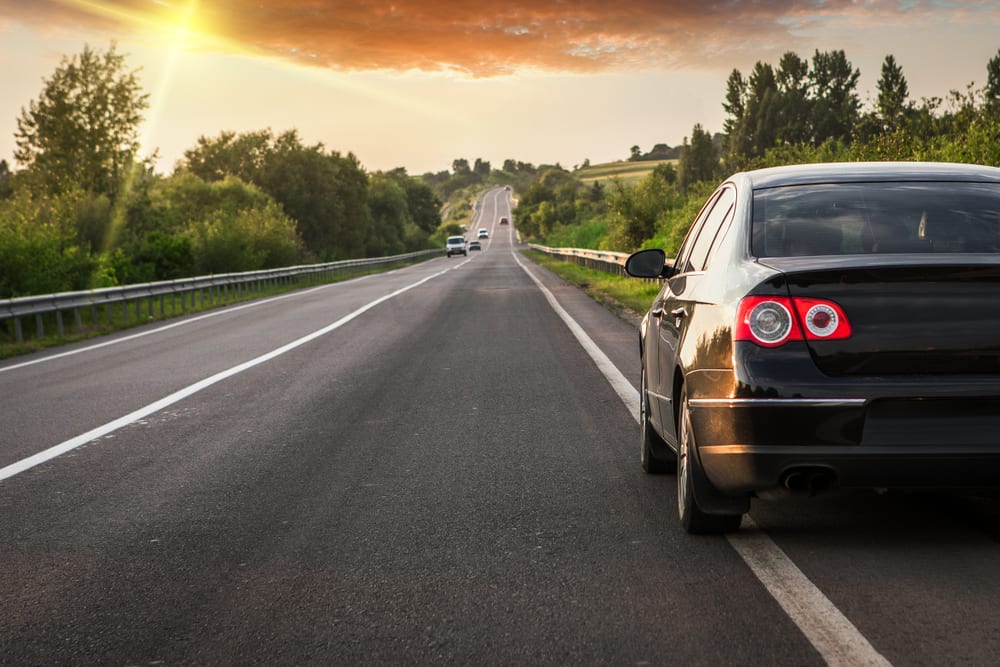 black car driving on asphalt road